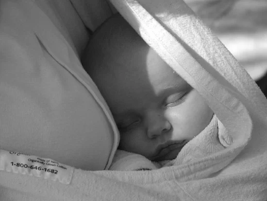 baby sleeping in mothers arms