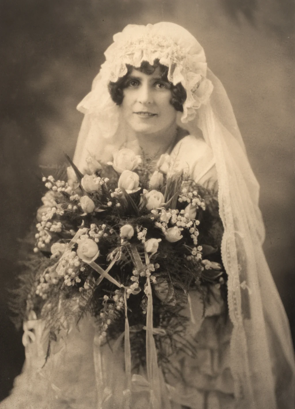 a vintage photo of a bride in her wedding dress with a bouquet