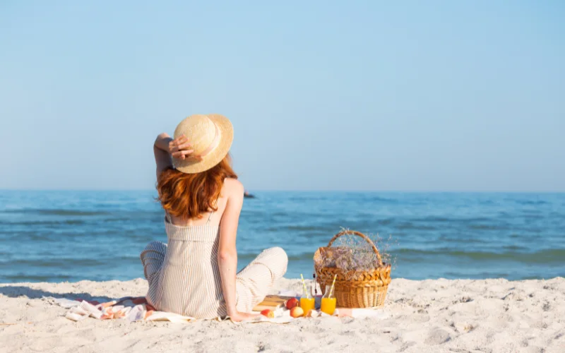 a woman enjoying a picnic on a beach