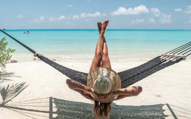 a woman posing on a swing on a beach