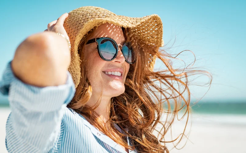 a woman posing with a hat in the wind